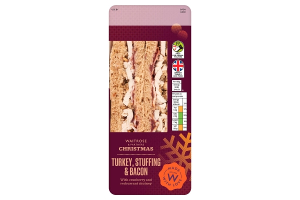 A Waitrose Christmas Turkey, Stuffing and Bacon sandwich in a dark red pack with the sandwich visible through a clear window